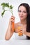 Young woman holding carrot and carrot juice