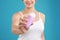 Young woman holding deodorant on teal background. Mockup for design