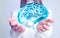 Young woman holding digital image of brain in hands on background, closeup