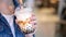 Young woman is holding, drinking brown sugar flavored tapioca pearl bubble milk tea with glass straw in night market of Taiwan,