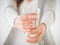 Young woman holding drinking water glass in her hand.