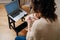 Young woman holding embroidering loop, watching instructions on laptop