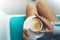 Young woman holding in female hands and drink hot aroma cup of coffee cuppuccino in breakfast time, hipster traveler girl