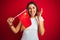 Young woman holding flag of China over red isolated background very happy and excited, winner expression celebrating victory