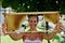 Young woman holding frame with honeycomb