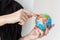 Young woman holding a globe of planet Earth, Showing by finger to Ukraine close-up