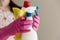 Young woman holding group of cleaning supplies. Household equipment, spring-cleaning, tidying up, cleaning service concept