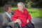 Young woman holding hand of old lady sitting in wheelchair