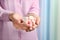 Young woman holding handful of tasty jelly candies on blurred background. Space for text