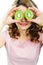 Young woman holding kiwi fruit for her eyes