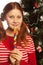 young woman holding lolly pop. Christmas tree.