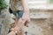 Young woman holding man`s hand and leading him on stone step background.