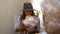 Young woman holding mycelium substrate with lion mane mushrooms and sniffing it