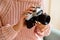 Young woman holding an old vintage camera. A cozy knitted pink sweater. Homemade photo on the couch. cozy autumn or