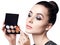 Young woman holding palette for contouring face.