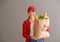 Young woman holding paper bag with fresh products on grey background. Food delivery service