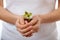 Young woman holding plant, coleus sprout