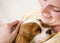 Young woman holding puppy on couch