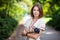 Young woman holding retro style camera in park