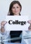 Young woman holding a sheet of paper with the text college