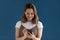 Young woman holding smartphone smiling using new apps studio shot