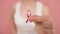 Young woman holding symbolic pink ribbon between her fingers. Breast cancer awareness month, pink october