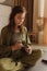 Young Woman holding Tarot cards and sitting in lotus pose on yoga mat, relaxed with closed eyes. Mindful meditation concept.