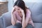 Young woman are holding their hands to the head in pain on the sofa at home. Young women have severe headaches from migraines