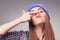 Young woman holding up fingers on nose and making silly expression