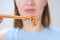 Young woman holding wooden sticks with Japanese fermented natto beans front view close-up, selective focus.