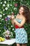 Young woman holds plate with strawberries and shows one berry