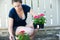 Young woman holds small crate of flowers