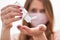 Young woman with home made pink cotton face mouth virus mask dropping anti bacterial alcohol rubbing gel on hand, detail to white