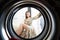 Young woman at home puts the dress in the drying machine.
