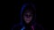 A young woman in a hood with a phone in her hands closeup. Hacker makes a hack through the phone. Blue and red light