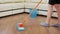 Young woman housekeeper with mop and bucket cleaning floor at home