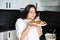 Young woman housewife with a plate of pancakes in the kitchen