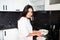 Young woman housewife preparing pancakes in the kitchen