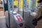 a young woman in a hygienic mask scans a card at the terminal in the subway