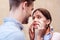 Young woman imitating crying while looking at smiling boyfriend