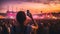 The young woman, immersed in the vibrant atmosphere of the music festival, captures the magic of the moment with her smartphone.