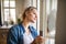 Young woman indoors at home, cleaning window.