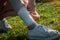 The young woman injured the tendons on her leg during an outdoor jogging. Self-bandaging. Running leg injury accident woman