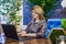 A young woman interior designer is working in her office at a computer. Green office, live plants in an office space