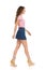 Young Woman In Jeans Mini Skirt And Wedge Shoes Is Walking. Side View