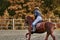 Young woman jockey in white black dress and black boots, takes part in equestrian competitions