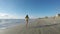 Young woman jogging along the sea on sandy beach