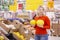 Young woman with juicy melons in the supermarket