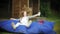 Young woman jumping lying in a lounge area of the park on soft puffs