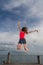 Young woman jumping at the pier